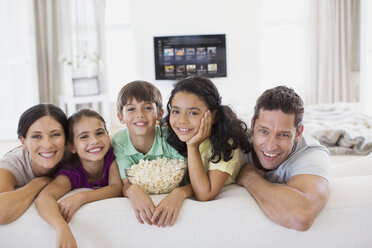 Familie entspannt sich gemeinsam auf dem Sofa im Wohnzimmer - CAIF19336