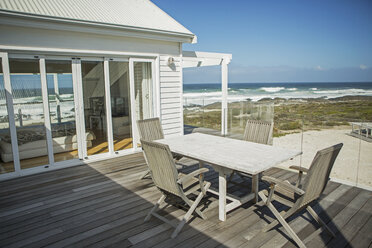 Tisch und Stühle auf dem Balkon mit Blick auf den Strand - CAIF19338