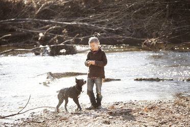 Junge mit Hund am Fluss stehend - CAVF09663