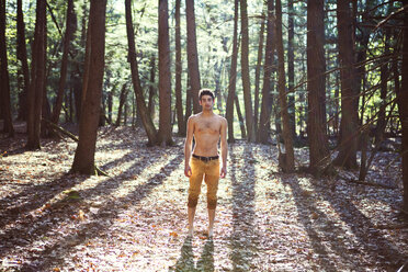 Porträt eines Mannes, der auf einem Feld im Wald steht - CAVF09708