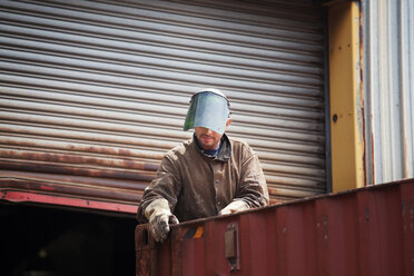 Mann schaut bei der Arbeit auf einen Frachtcontainer - CAVF09749