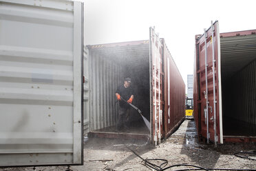 Männer in voller Länge bei der Reinigung eines Frachtcontainers - CAVF09759