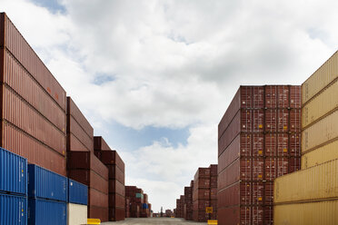 Stapel von Frachtcontainern an einem kommerziellen Dock vor bewölktem Himmel - CAVF09765