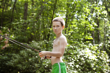Seitenansicht eines Jungen beim Fischen im Wald - CAVF09869
