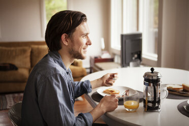 Side view of man having breakfast at home - CAVF09970