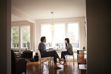 Couple sitting by breakfast table in morning at home - CAVF09972