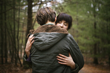 Ehepaar umarmt sich im Wald stehend - CAVF10011