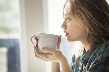 Nahaufnahme einer Frau, die zu Hause eine Kaffeetasse hält - CAVF10025