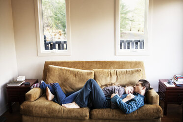 Blick von oben auf ein schlafendes Paar auf dem Sofa zu Hause - CAVF10044