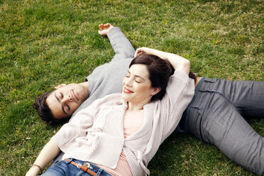 High angle view of happy couple lying on grass at park - CAVF10161