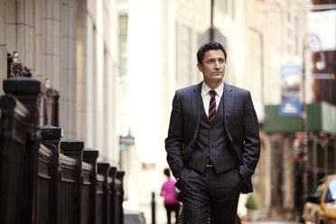 Confident businessman walking on city street - CAVF10223