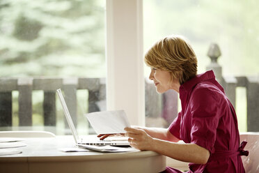 Frau benutzt Laptop für Online-Einkäufe zu Hause - CAVF10283