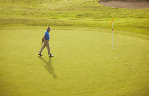 Mann geht auf Golfplatz, lizenzfreies Stockfoto