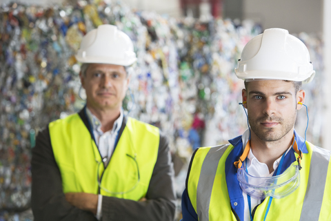 Seriöse Arbeiter im Recyclingzentrum, lizenzfreies Stockfoto