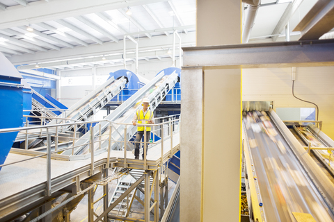 Arbeiter auf einer Plattform im Recyclingzentrum, lizenzfreies Stockfoto