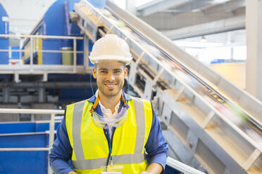 Lächelnder Arbeiter im Recyclingzentrum - CAIF19619