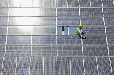 Arbeiter bei der Untersuchung eines Solarpanels in einer ländlichen Umgebung - CAIF19652