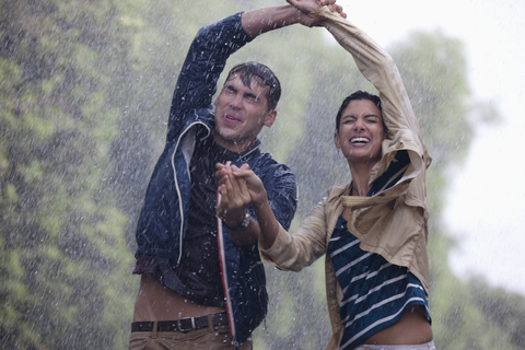 Glückliches Paar tanzt im Regen, lizenzfreies Stockfoto