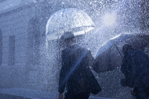 Geschäftsleute mit Regenschirmen im Regen, lizenzfreies Stockfoto