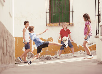 Kinder spielen mit Fußball in der Gasse - CAIF19796