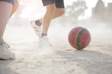 Kinder spielen mit Fußball im Sand - CAIF19797