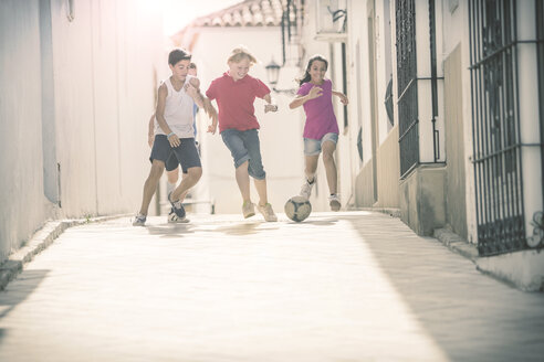 Kinder spielen mit Fußball in der Gasse - CAIF19802