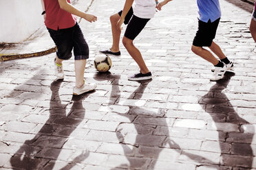 Kinder spielen mit Fußball in der Gasse - CAIF19809