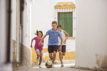 Kinder spielen mit Fußball in der Gasse - CAIF19811