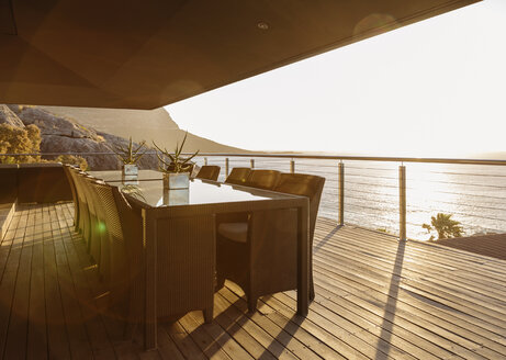 Dining table on luxury patio overlooking ocean - CAIF19855