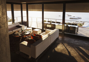 Modern living room overlooking ocean - CAIF19856