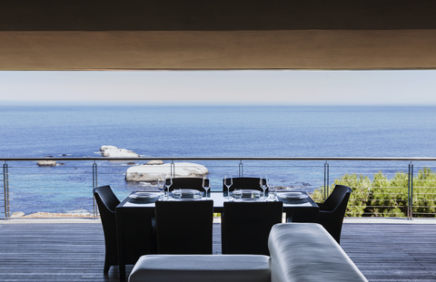 Esstisch auf dem Luxusbalkon mit Blick aufs Meer, lizenzfreies Stockfoto