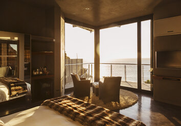 Luxuriöses Schlafzimmer mit Blick auf das Meer bei Sonnenuntergang - CAIF19878