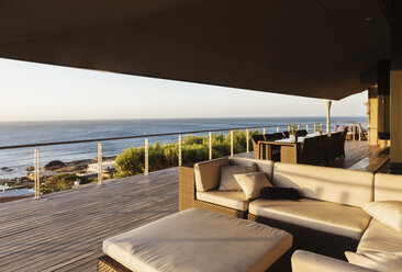 Sofa and table on luxury patio overlooking ocean - CAIF19882