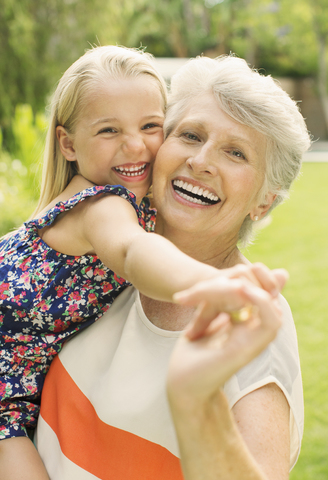 Lächelnde Großmutter hält Enkelin, lizenzfreies Stockfoto