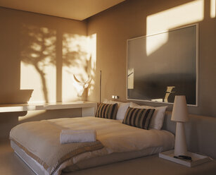 Spiegelung von Bäumen an der Wand in einem modernen Schlafzimmer - CAIF19935