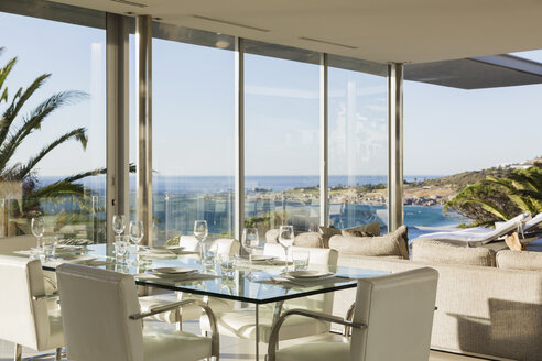 Set table in modern dining room overlooking ocean - CAIF19963