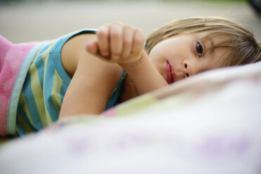 Portrait of girl lying on bed at home - CAVF10381