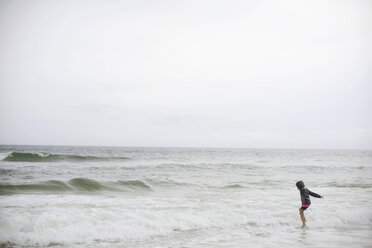 Side view of girl playing in sea against clear sky - CAVF10413