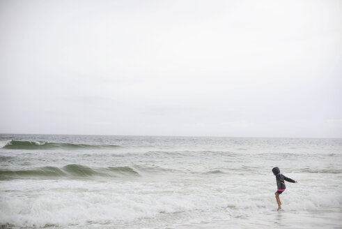 Seitenansicht eines im Meer spielenden Mädchens bei klarem Himmel - CAVF10413