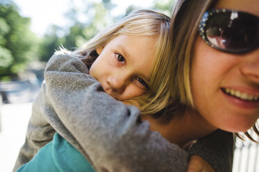 Portrait of daughter having piggyback ride on mother - CAVF10424