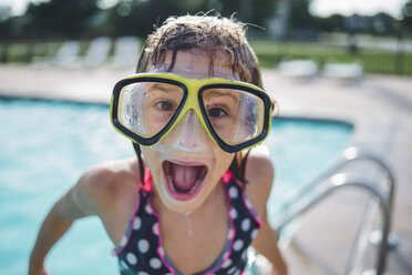 Porträt eines Mädchens mit offenem Mund, das eine Schwimmbrille trägt und am Beckenrand steht - CAVF10477