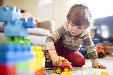 Niedriger Blickwinkel des Jungen spielt mit Spielzeug-LKW zu Hause - CAVF10526