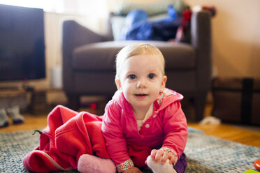 Portrait of cute boy sitting on floor at home - CAVF10532