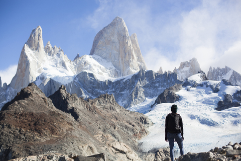 Rear view of woman standing against snowcapped mountains stock photo