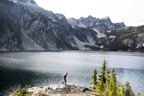 Seitenansicht eines Wanderers auf den Felsen am Snow Lake, lizenzfreies Stockfoto