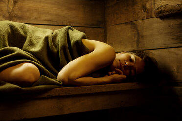 In eine Decke gewickelte Frau entspannt sich in der Sauna - CAVF10600