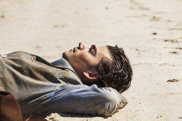 Mann liegend auf Sand am Strand - CAVF10631