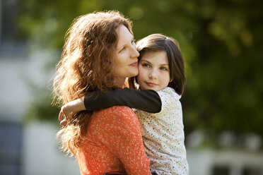 Side view of mother carrying daughter - CAVF10724