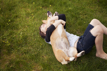 High angle view of girl playing with dog in yard - CAVF10731