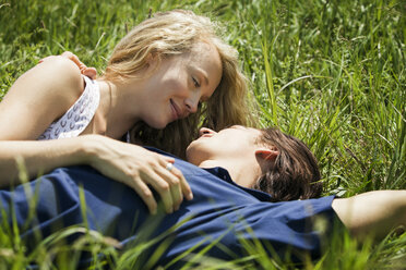 Couple lying on grassy field - CAVF10744